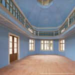Achteckiger Raum mit blauen Wänden, verzierter Decke, Fensterzone oben und terrakottafarbenem Boden auf der Heidecksburg.