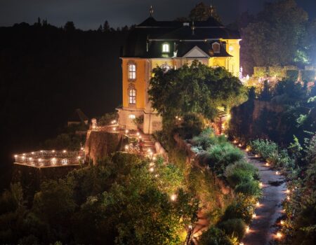 Beleuchteter Schlosspark mit illuminiertem Weg und Terrasse bei Nacht, führend zum angestrahlten Rokokoschloss Dornburg – stimmungsvolle Aufnahme der Dornburger Schlössernacht in Thüringen.